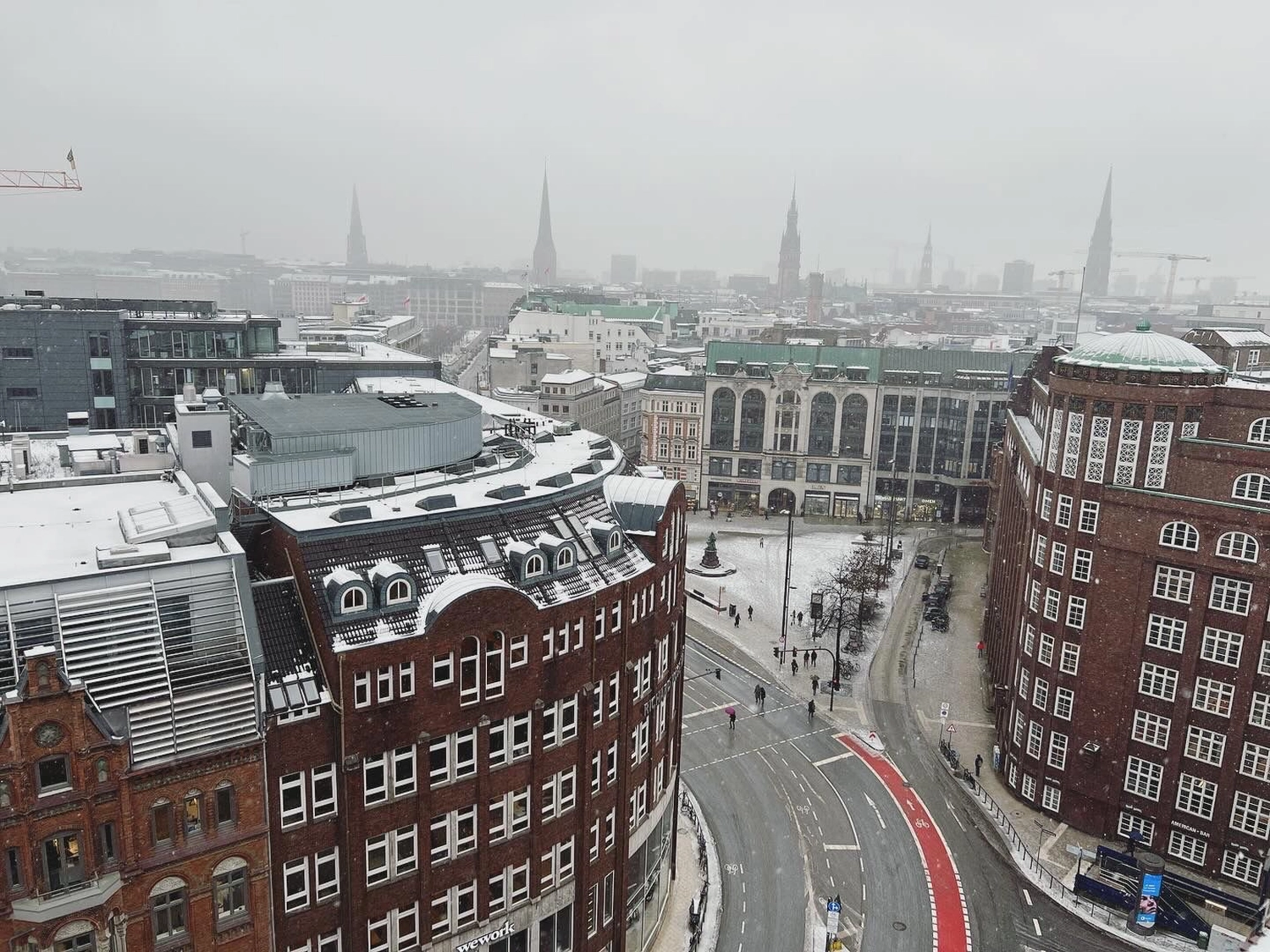 Fugentechnik Buchen - Bau - Schneebedeckte Stadtkreuzung mit roten Backsteingebäuden und Kirchtürmen im nebligen Hintergrund