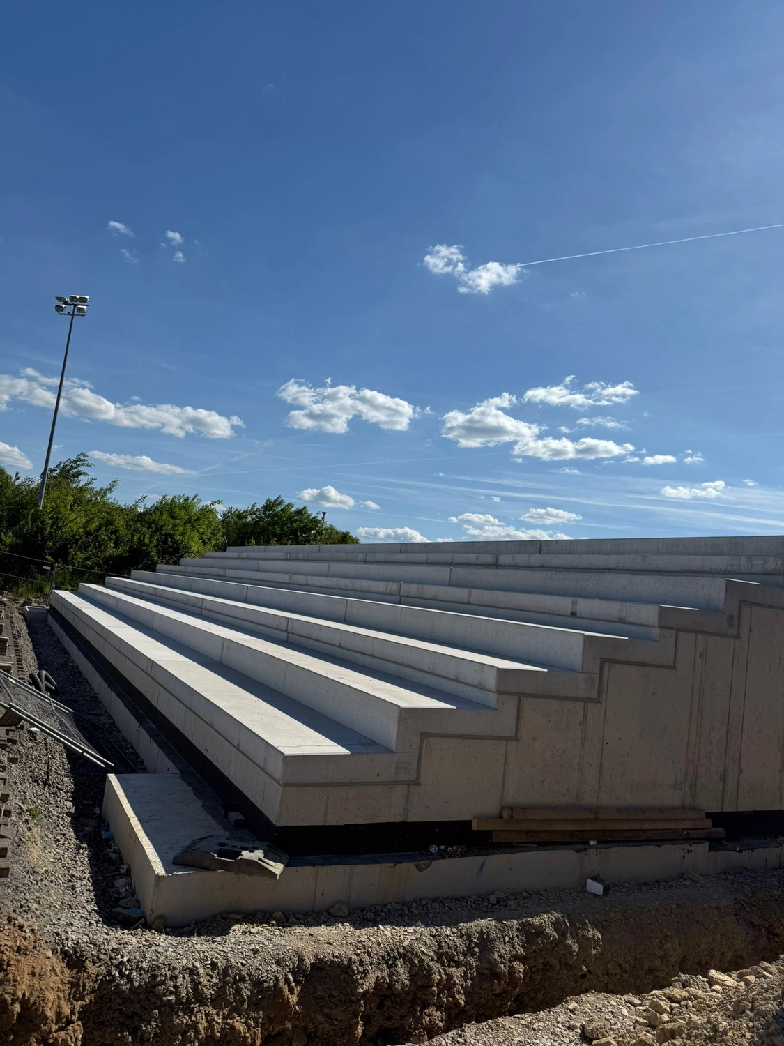 Fugentechnik Buchen – Bau – Betontribünen im Bau im Freien an einem sonnigen Tag mit blauem Himmel und vereinzelten Wolken