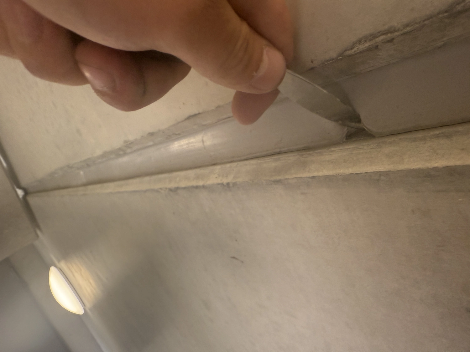 Fugentechnik Buchen - Bau - Manuelles Ablösen eines Streifens von sich zersetzender Dichtungsmasse von einer gefliesten Wandecke